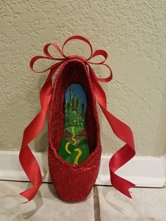 a pair of red glitter shoes with a wizard's castle painted on the shoe