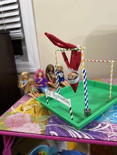 a group of dolls sitting on top of a table with an object in the shape of a football goal