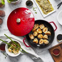 a table topped with plates and bowls filled with food next to utensils on top of a white counter