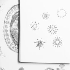 an open notebook with drawings on it next to shells and seashells in black and white