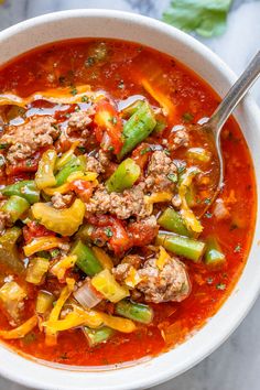 a close up of a bowl of soup with meat, peppers and onions in it