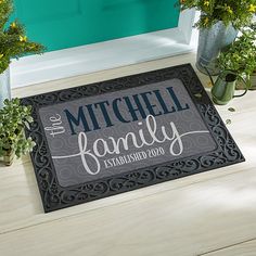 a door mat that says the mitchell family established on it with flowers in vases next to it