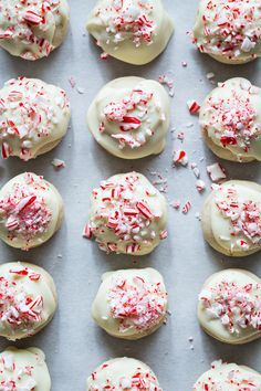 white frosted cookies with red sprinkles on a baking sheet, ready to be eaten