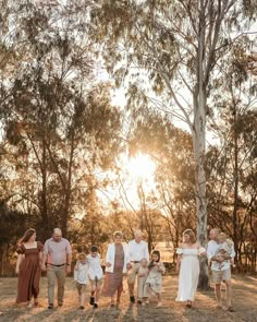 a family walking through the woods at sunset