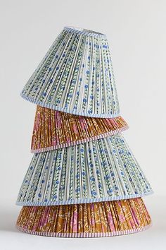 three tiered lampshade made out of different colored paper strips on white background