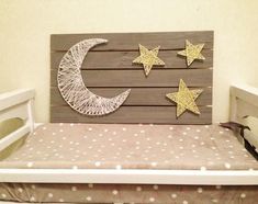 a crib made out of wood with stars and the moon on it's side