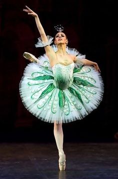 the ballerina is dressed in green and white