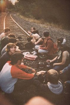 a group of people sitting next to each other on train tracks with the words graded above them