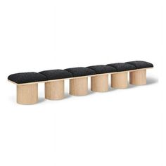 the bench is made out of wood and has four black cushions on top of it