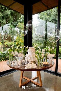 a table topped with lots of bubbles filled with flowers and cake sitting on top of it