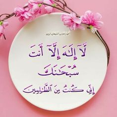 a white plate with pink flowers on it and the words in arabic are written below