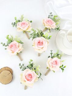 pink and white flowers are arranged on top of each other next to a coffee cup