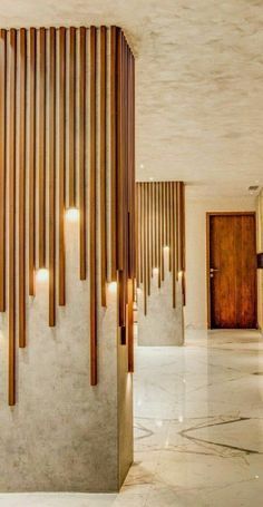 the entrance to a modern home with wood slats on the wall and marble flooring