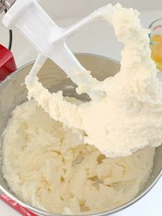 a mixing bowl filled with white batter next to an electric mixer