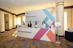 three women sitting at a table in front of a sign that says bnm business connect