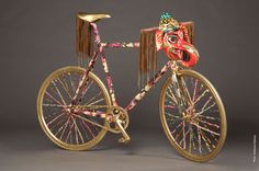 an elaborately decorated bicycle is shown against a gray background