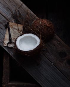 a coconut sitting on top of a wooden table next to a pair of scissors