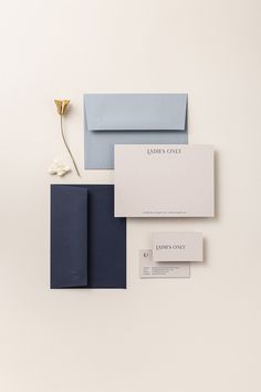 an assortment of stationery items including envelopes, business cards and flowers on a white surface