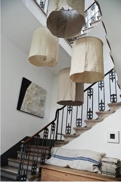 several lamps hanging from the ceiling above a staircase