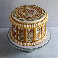 a decorated cake sitting on top of a glass plate