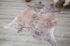 a cowhide rug is on the floor next to a teddy bear