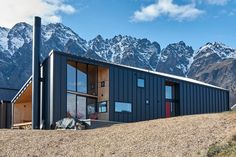 a house on top of a hill with mountains in the background