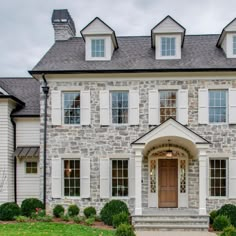 a large stone house with white trim and windows