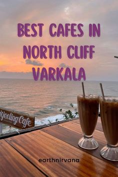 two drinks sitting on top of a wooden table next to the ocean with text overlay saying best cafe in north cliff, varka