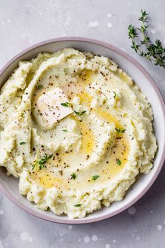 a bowl filled with mashed potatoes on top of a white tablecloth next to a spoon