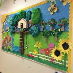 a bulletin board is decorated with flowers and trees on the wall, while bees are flying around