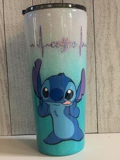 a blue and white tumbler cup with stitching on the side that says, i love stitch