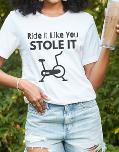 a woman wearing ripped shorts and a white t - shirt with the slogan ride it like you stole it