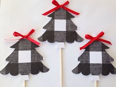 three paper christmas trees with red bows on them