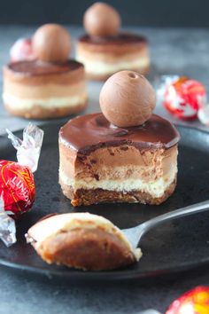 a chocolate dessert on a black plate with candy in the background