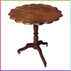 an old fashioned wooden table with wheels on it's legs and a flower shaped top