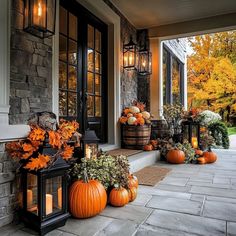 a front porch decorated for fall with pumpkins and lanterns