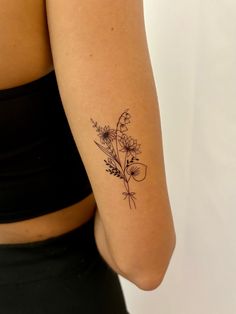 a woman with a flower tattoo on her left arm and the other arm behind her