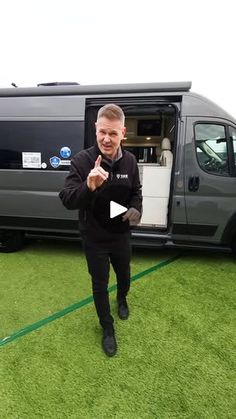 a man standing in front of a van giving the thumbs up