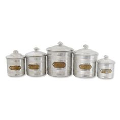 six metal canisters with gold accents and lids on each one, all in different sizes