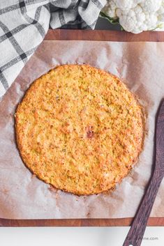 an uncooked pizza sitting on top of a cutting board next to a knife