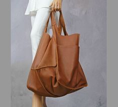 "Oversized carryall handbag, Leather tote bag with pocket, Giant oversize tote bags, Carryall shopper bag soft leather, Camel brown tote This oversized bag has been carefully designed to be the perfect everyday bag. The size makes it practical for carrying everyday essentials. Made from 100 percent Italian leather. This bag is available in different colors, check in my store.   * Includes two large internal pockets for mobile phone and other small items. * Top closure magnet for security. Height: 39 cm / 15.3\" Height from top of handle to base: 68 cm / 26.8\" Handle drop: 26 cm / 10.2\" Width: 34 - 74 cm / 13.4\" - 29.1\" Depth: 28 cm / 11\" The leather of this product has been produced in an audited and certified tannery in Italy.    To return to my shop, simply click here: https://www.e Chic Brown Shoulder Bag With Pockets, Versatile Brown Satchel Weekender Bag, Large Brown Satchel For Daily Use, Brown Shoulder Bag With Pockets For Fall, Fall Brown Shoulder Bag With Pockets, Brown Hobo Bag With Pockets For Shopping, Large Brown Shoulder Bag For Travel, Large Brown Bags With Double Handle, Brown Large Capacity Weekender Bag For Everyday