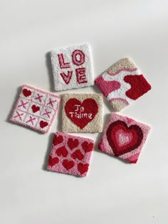 four pieces of felt with hearts and love written on them, all in different colors