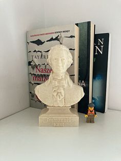 there is a small statue next to some books