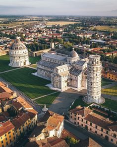 an aerial view of the leaning tower of pisa in italy, with other buildings surrounding it