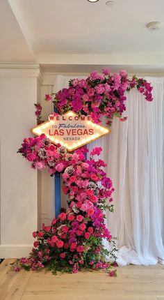 a neon sign with pink flowers growing on it