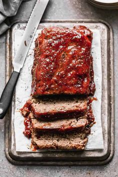 sliced meatloaf on a tray with sauce