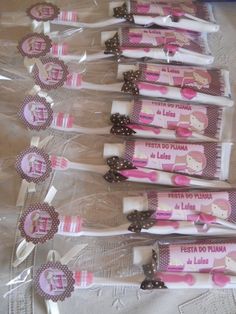 five toothbrushes wrapped in clear plastic with pink and brown bows on them, sitting next to each other