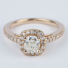 an engagement ring with a cushion cut diamond surrounded by small round diamonds on the band