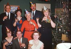 a group of people standing next to each other wearing party hats