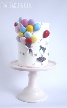 there is a cake with balloons on it